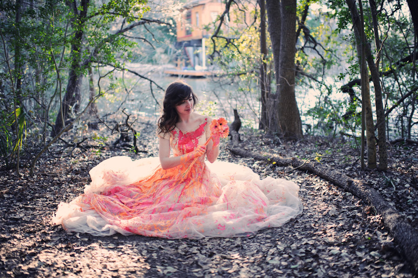 bride sitting with paint over wedding dress
