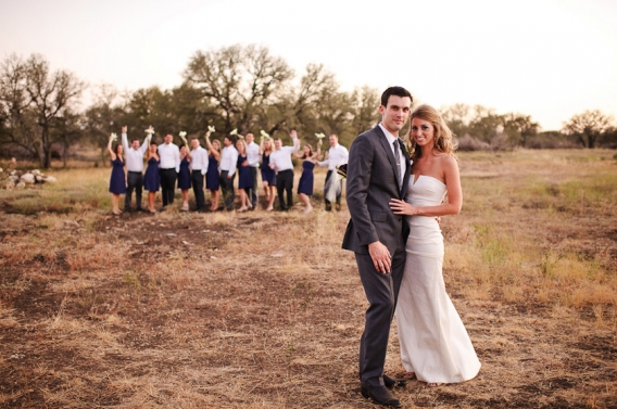 bride and groom with bridal party in the background