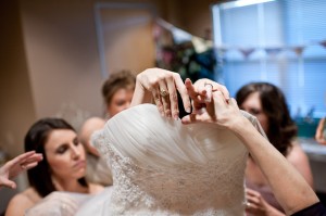 getting into the wedding dress with the help of mother of bride and bridesmaids