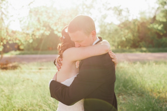 the bride and groom hugging in the sunlight