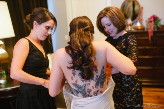 tattooed bride getting into her dress