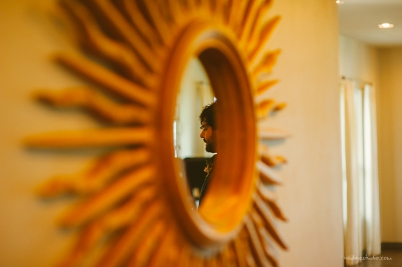 refelection of the groom in a sun mirror