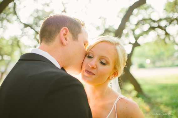 groom kissing his bride on the cheek