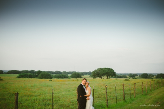 driftwood wedding with the sea of flowers behind them
