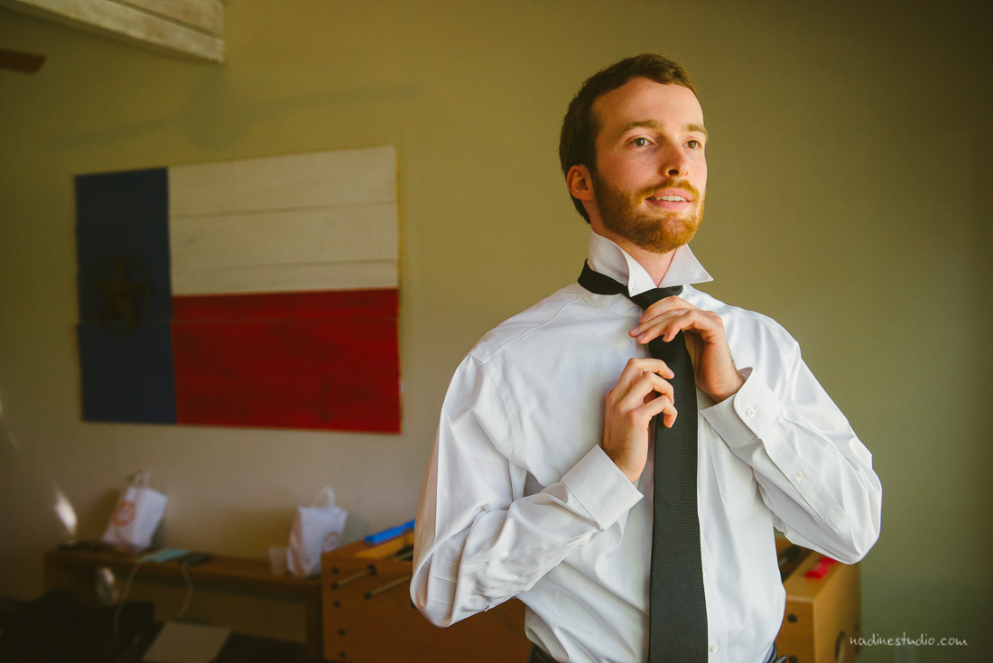 groom getting ready and tying tie