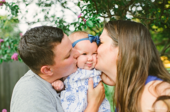 both mothers kissing child