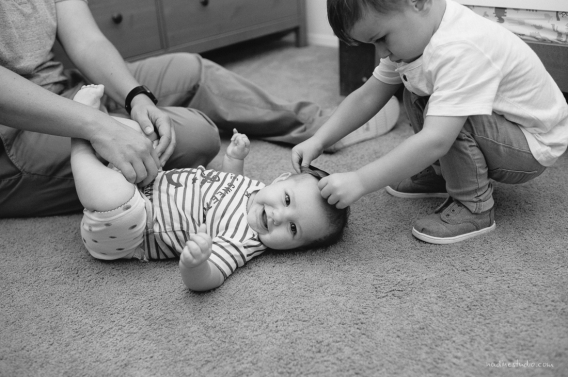 brother helping baby dress