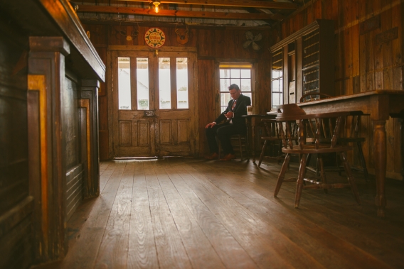 groom waiting in a dimly root room in a ranch